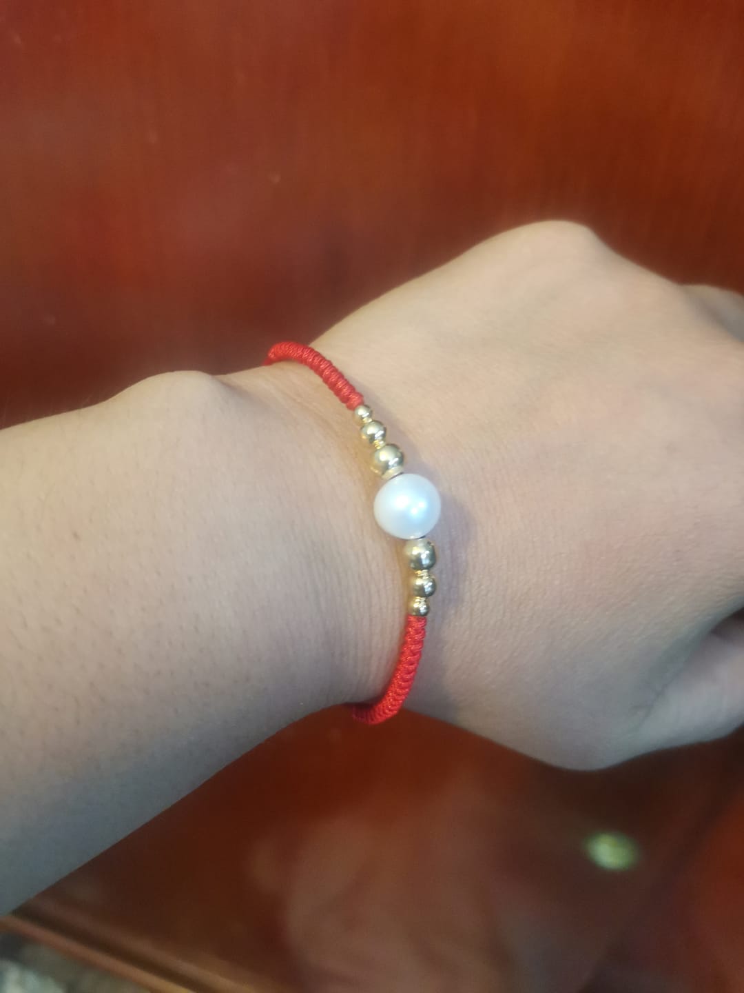 Customer photo review of Pulsera hilo rojo ajustable perla natural bolita chapa de oro