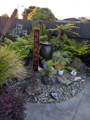 Customer photo review of Black metal Long Koru pattern on Rustic Oak Post-Garden Art