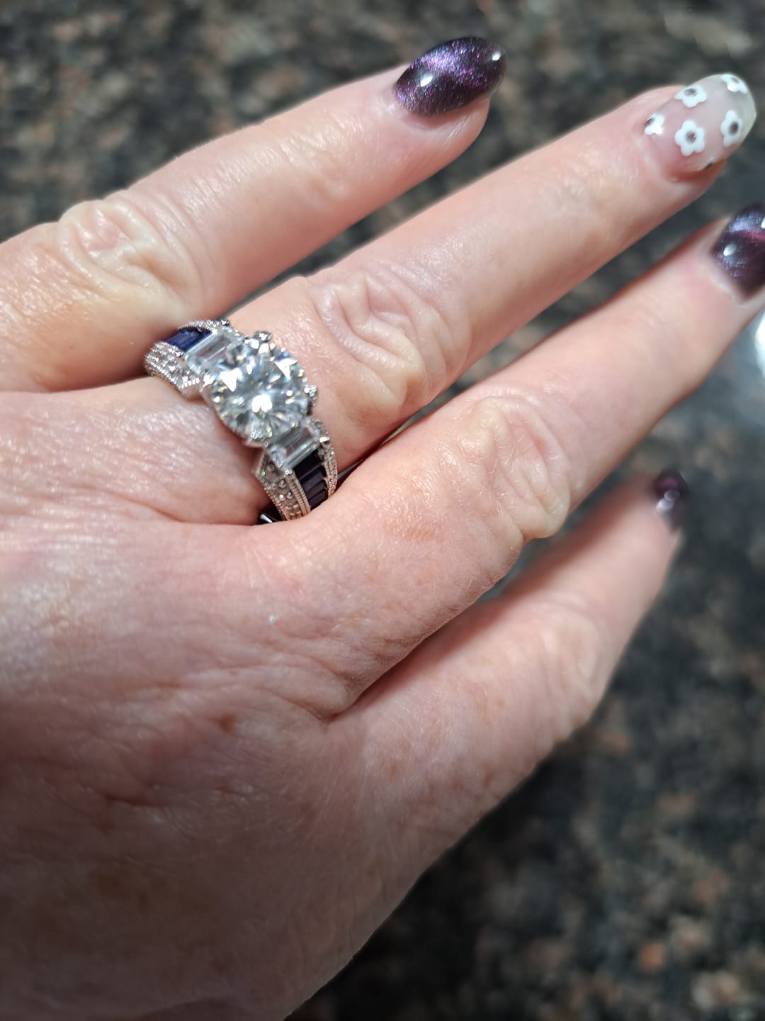 Customer photo review of Round Moissanite And Emerald-Cut Sapphire Channel Set Milgrain Engagement Ring