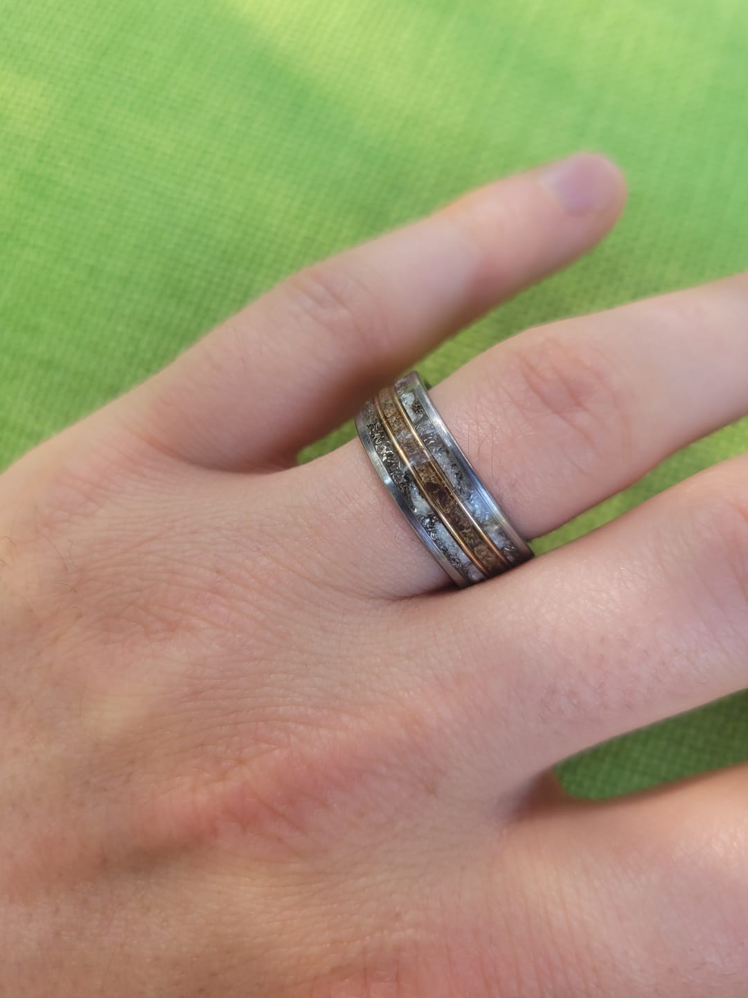 Customer photo review of Flat tungsten ring filled with moonstone/white opal/blue glow mixed with meteorite and trex bone fossil divided by two 18k golden wires 8 mm for Daniel