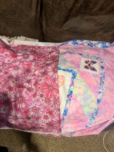 Reviewer's pink floral Sleepovers Quilt Backing fabric laid out next to a coordinating patchwork quilt top.