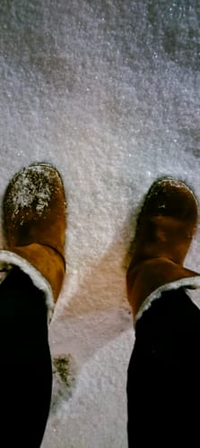 Asiakkaan ruskeat Vaistoa Huurre -paljasjalkabootsit lumisella maalla.