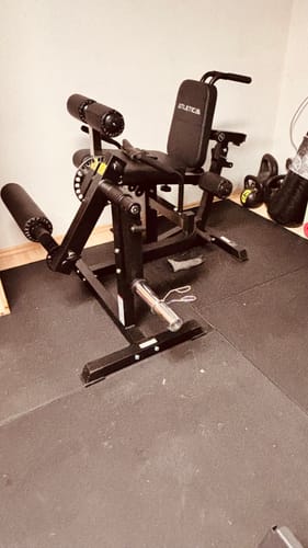 Ein Kunde zeigt den aufgebauten, stabilen Fullbody Multitrainer auf einer schwarzen Fitnessmatte.