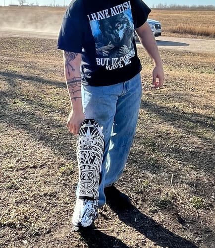 Reviewer holding one of the white and black Maya Calendar Print Muay Thai Shin Guards while standing outdoors.