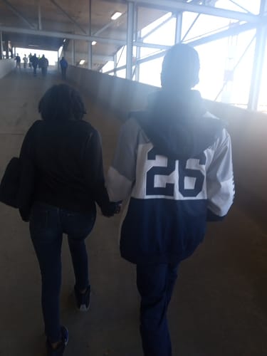 Customer from behind wearing a custom color-block letterman hoodie with the number 26 on the back.