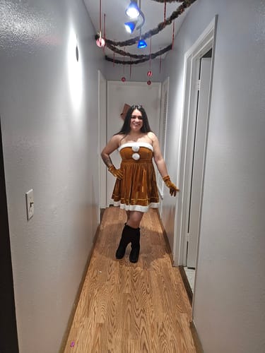 Reviewer in a hallway wearing the strapless brown velvet dress with matching gloves.