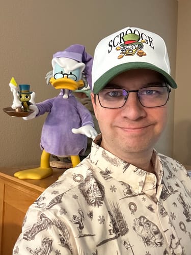 Reviewer wearing the Mickey's Christmas Carol shirt with its parchment-style sketch illustrations.