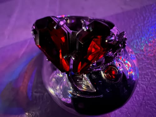 Customer's unique XL LUNA RING with red stones, shown in a close-up shot under purple lighting.