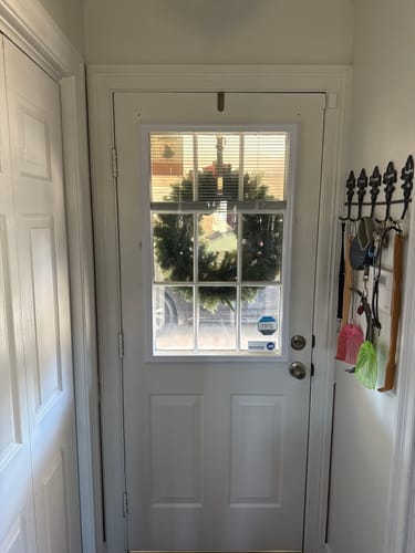 Reviewer's Add On Blinds Kit on a white door, with the blinds raised to show a wreath outside.