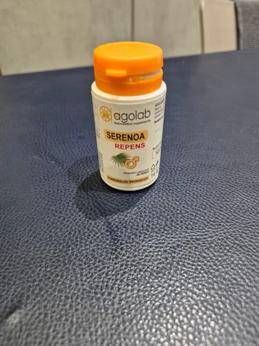 Recensore mostra il flacone bianco dell'integratore Serenoa Repens con tappo arancione.