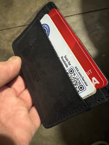 Customer holding their black Hamlin Card Holder with several cards inserted in the slots.