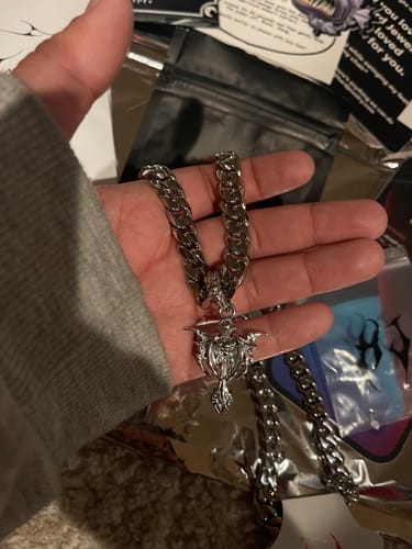 Reviewer holding the thick 10MM HEAVY CUBAN CHAIN in their hand, showing its size and a pendant.