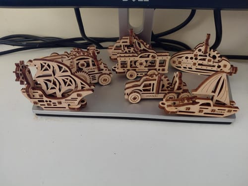 לקוח מציג את דגמי העץ המורכבים של פאזל U-Fidget Ships, כולל סירת מפרש וצוללת.