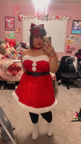 Reviewer taking a mirror selfie in the red sequined Christmas dress with white fur trim.