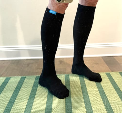 Reviewer standing while wearing the black Performance Eucalyptus Compression Socks, showing the knee-high fit.