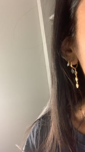 Close-up of a reviewer's ear wearing the gold Frosted Marquise huggies in a stacked ear piercing.