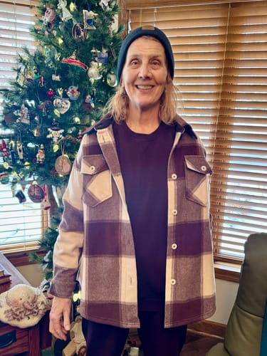 Reviewer wearing the Elsa Long Sleeve shirt in Grape Harvest Melange, layered under a plaid jacket indoors.