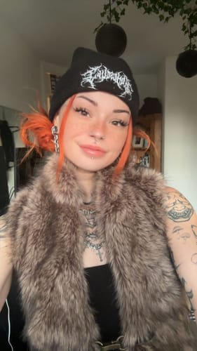 A reviewer wearing fluffy Bunny lashes that complement their alternative style with orange hair.