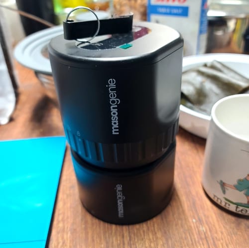 Customer's black Mason Genie Vacuum Sealer Kit sitting upright on a wooden table, ready for use.