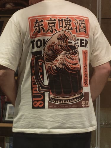 Reviewer shows the back of their cream Beer Wave T-Shirt, highlighting the vibrant Japanese-style graphic.