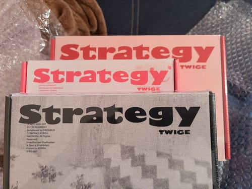 Customer's photo of the three different versions of the TWICE "STRATEGY" mini album they received.