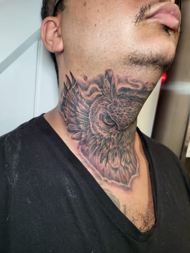 Customer's side view of a detailed owl neck tattoo, done after using Painless Tattoo numbing cream.