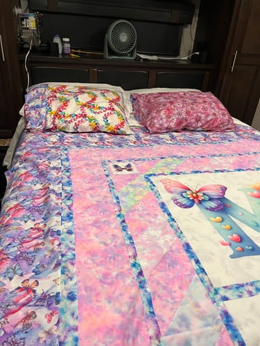 Reviewer shows the blue and purple Liquid Marble Fabric used as decorative borders on a homemade quilt.