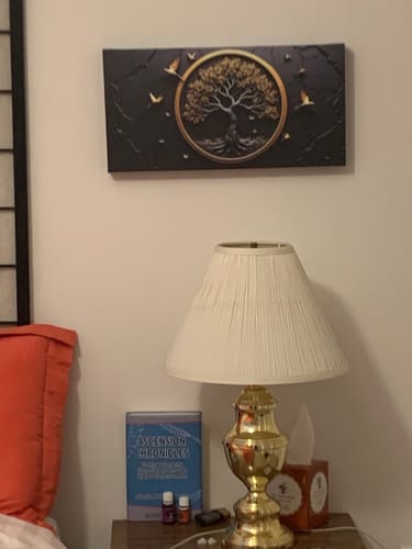 Customer's 3D Celtic Tree of Life Wall Art hanging on a bedroom wall above a nightstand with a lamp.