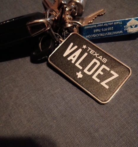 Customer's customized Texas Black Plate Pendant, with the name 'Valdez', attached to a set of keys.