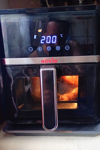 Client folosind friteuza Novio StonePro, cu afișajul digital pornit, setat la 200 de grade în timpul gătirii.