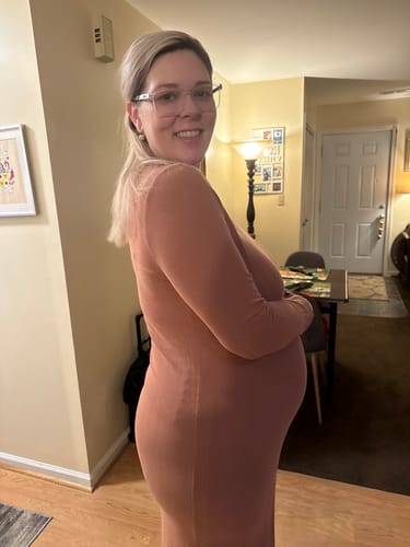 Reviewer shows her baby bump at 33 weeks while wearing TOAST MATERNITY tights under a dress.