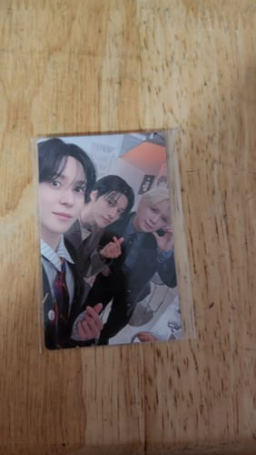 Customer's close-up of a photocard from the ATEEZ 2026 Season's Greetings showing three members taking a selfie.