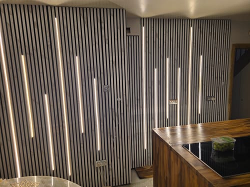 Reviewer's white marble acoustic wall panels installed in a kitchen with custom vertical LED lights.