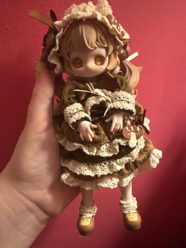 Reviewer holding the Kiseki Vintage Treasures action figure, showing its detailed brown and green dress with lace trim.