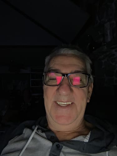 Close-up of a reviewer smiling in a dark room, showing their Pop On Veneers.