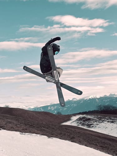A reviewer performing a mid-air ski jump while wearing the baggy khaki snow pants.