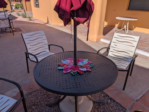 Reviewer's Petal Pop Zinnia pattern made into a colorful centerpiece around a patio umbrella.