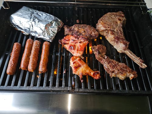 Customer's USDA Choice Family Steak Pack, including a large bone-in steak, grilling on a barbecue.