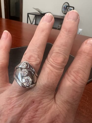 Customer wearing a custom 3-stone ring. The wide, platinum-plated silver band holds three brilliant moissanite stones.