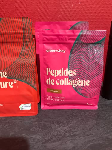 Client montrant ses deux sachets rose vif de Peptides de Collagène, saveur chocolat.