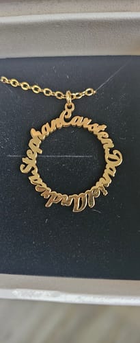 Kundenfoto der personalisierten Namenskette Kreis der Liebe. Der goldene Anhänger mit Namen liegt in einer Box.