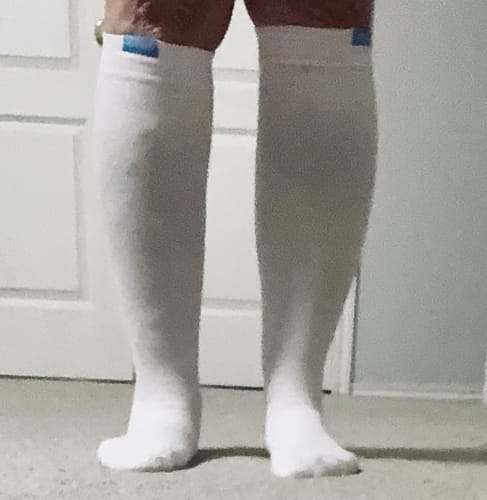 Reviewer wearing the white Performance Eucalyptus Compression Socks, showing the non-constricting fit on their calves.