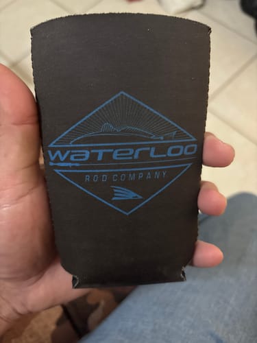 Customer holding the black Waterloo Slim Koozie, showing the blue diamond logo.