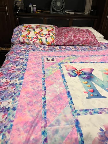 Customer's pink and purple Japanese Style Tie Dye Fabric used in a colorful quilt on a bed.
