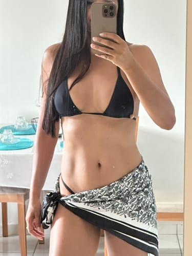 Cliente em foto de espelho, mostrando o ajuste do Top Fita Preto em seu corpo.