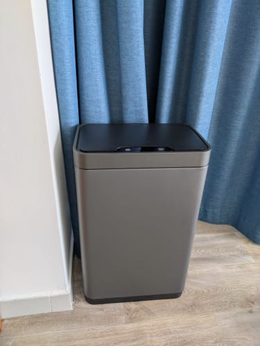 Customer's titanium gray sensor bin with a black lid, shown standing on a light wood-look floor.