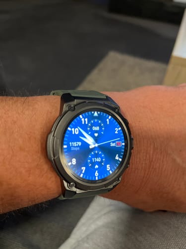 Customer's wrist wearing a rugged smartwatch with a green strap and a glowing blue digital face.