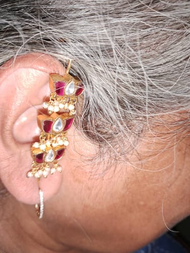 A customer wears the Eshika 22k Gold Plated Earpin, showing the detailed red kundan and pearl drop design on their ear.