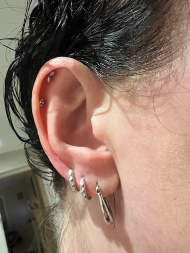 Customer's ear showing two Floating Marquise Flatback Silver studs worn in the upper cartilage piercings.