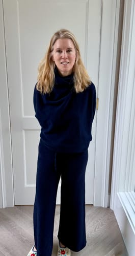 A reviewer models the navy Relaxed Pants indoors, showing their full-length and wide-leg style.